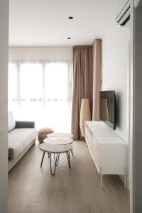 a living room with a couch and a tv and a table at Lumen Mare by SH Hoteles in Valencia