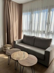 Lumen Mare by SH Hoteles في فالنسيا: غرفة معيشة مع أريكة وطاولتين
