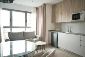 Lumen Mare by SH Hoteles في فالنسيا: مطبخ وغرفة معيشة مع طاولة وكراسي
