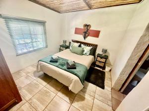 a bedroom with a bed and a window at Kranskloof Country Lodge in Oudtshoorn