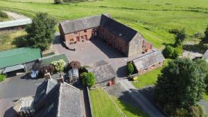 una vista aérea de un antiguo edificio de ladrillo en un campo en Bank Top Farm Cottages en Stoke on Trent