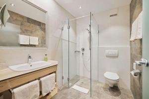 uma casa de banho com um chuveiro, um lavatório e um WC. em Gasthaus Hotel Oberwirt em Ebbs
