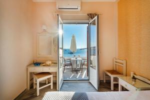 sypialnia z drzwiami prowadzącymi do oceanu w obiekcie Irene Hotel - Beachfront w mieście Parikia