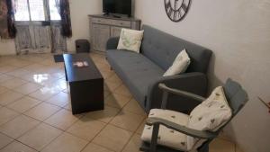 ein Wohnzimmer mit einem Sofa und einem Tisch in der Unterkunft Mas Maurane - Le Romarin aux portes d'ARLES in Tarascon