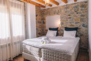 1 dormitorio con 1 cama grande y pared de piedra en Can Blanc de Montagut, en Montagut