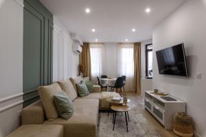 uma sala de estar com um sofá e uma televisão em Apartment BonBon next to Gondola em Bansko