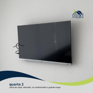 Elle comprend une télévision à écran plat suspendue au mur. dans l'établissement Nox Temporada - Flat 201 a 4km da Feira e Shopping Caruaru, à Caruaru