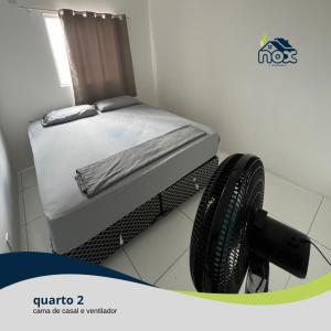- une petite chambre avec un lit sur un portant dans l'établissement Nox Temporada - Flat 201 a 4km da Feira e Shopping Caruaru, à Caruaru