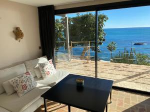 a living room with a couch and a view of the ocean at El jardin Botánico Villa LUZ in Altea