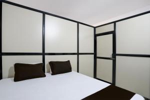 ein Schlafzimmer mit einem weißen Bett mit zwei Kissen in der Unterkunft OYO Madhupushpa Farm House in Rāmtek