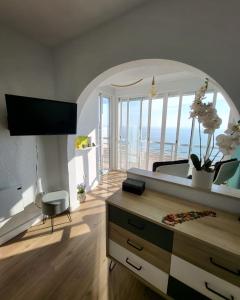 アリカンテにあるÁtico Playa Muchavista - El Campelloの鏡とテーブル付きのベッドルーム1室が備わる客室です。
