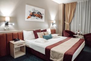 um quarto de hotel com uma cama e uma cadeira em Unirea Hotel & Spa em Iaşi