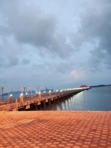 a long pier with lights on the water at The Rock Hut in Ko Lanta