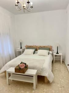 カルドナにあるCan Bastidaの白いベッドルーム(大型ベッド1台、テーブル2台付)