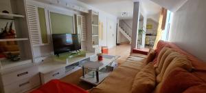 a living room with a couch and a television at Vila Roxy Poiana Brasov in Poiana Brasov
