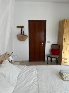 1 dormitorio con cama, puerta y silla en Can Bastida, en Cardona