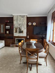 a living room with a table and chairs and a fireplace at Can Bastida in Cardona