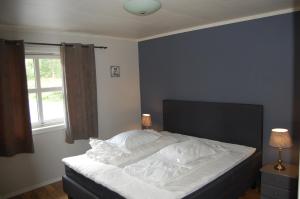 una camera da letto con un letto con lenzuola bianche e una finestra di Feriehus nede ved sjøen inntil 6 pers a Vestnes