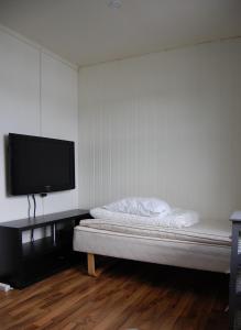 a bedroom with a bed and a flat screen tv at Feriehus nede ved sjøen inntil 6 pers in Vestnes