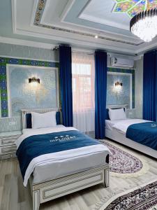 a bedroom with two beds with blue curtains and a ceiling at Diplomat Premium Hotel in Samarkand