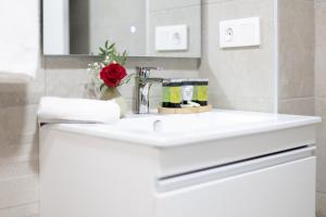 a white bathroom sink with a red rose on it at DormForYou Ciudad de las ciencias Terraza in Valencia