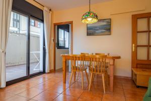 - une salle à manger avec une table et des chaises en bois dans l'établissement HomeHolidaysRentals Fortuny - Costa Barcelona, à Pineda de Mar