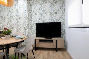 DormForYou Arena Delux في فالنسيا: غرفة معيشة مع تلفزيون على طاولة