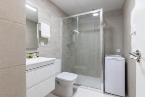 a bathroom with a toilet and a glass shower at DormForYou Arena Standard in Valencia