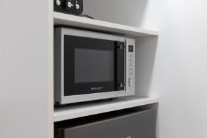 a microwave oven sitting on top of a shelf at DormForYou Arena Standard in Valencia