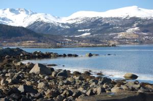 a large body of water with snow covered mountains at Feriehus nede ved sjøen inntil 6 pers in Vestnes