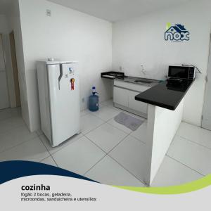 Nox Temporada - Flat 101 a 4km da Feira e Shopping Caruaru في كاروارو: مطبخ صغير مع ثلاجة ومكتب