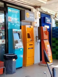 an atm machine next to a pay station in a store at The Rock Hut in Ko Lanta