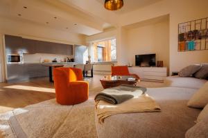 a living room with a couch and a kitchen at 2-Bedroom Apt Above Venti Restaurant Near Xpo in Zwevegem