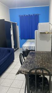 um quarto com uma mesa e um quarto com duas camas em Kitinete perto da praia e Shopping Brisamar em São Vicente, na Biquinha, temporada e mensal tudo incluso, mobiliado, wi fi, ventilador, elevador, horário flexível em São Vicente