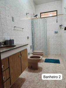 uma casa de banho com um WC e um chuveiro em Sítio da Cachoeira em Socorro