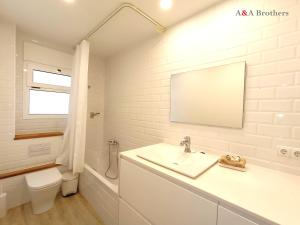 a bathroom with a sink and a toilet and a mirror at A&A Brothers -The Apartments- in S'Agaro