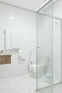 a bathroom with a toilet and a glass shower stall at Paradies Hotel Express in Jarinu