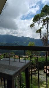 einen Balkon mit einem Tisch und Bergblick in der Unterkunft Skyland Garden Hotel and Resort in Baguio City