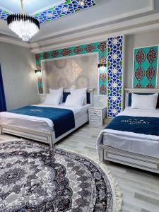 a bedroom with two beds and a rug at Diplomat Premium Hotel in Samarkand