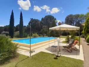 een zwembad met een parasol, een tafel en een stoel bij Spacious holiday home with private pool in Cazouls-lès-Béziers