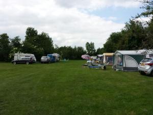 a group of tents and cars parked in a field at Camping Eefting in Rohel