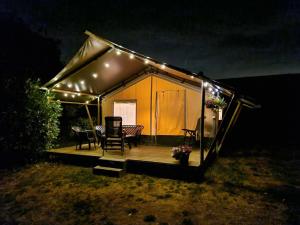 a tent with a table and chairs in it at night at Camping Eefting in Rohel
