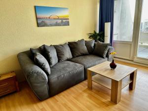 ein Wohnzimmer mit einem Ledersofa und einem Tisch in der Unterkunft Südstrand-Ferienwohnung Suhr in Burgtiefe auf Fehmarn 