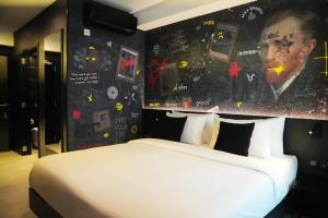 a bedroom with a bed with a large painting on the wall at SO City Hotel Adults Only in St. Julianʼs
