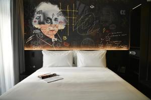 a bedroom with a bed with a painting on the wall at SO City Hotel Adults Only in St. Julianʼs