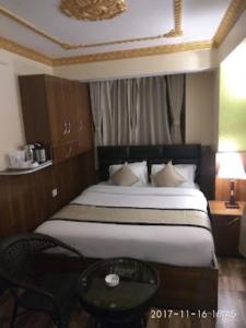 - une chambre avec un grand lit et une table en verre dans l'établissement HOTEL MOUNT ROYALE Darjeeling, à Darjeeling