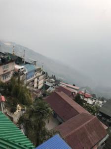 une ville avec des bâtiments et une montagne en arrière-plan dans l'établissement HOTEL MOUNT ROYALE Darjeeling, à Darjeeling