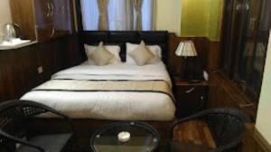 - une chambre avec un lit et une table en verre dans l'établissement HOTEL MOUNT ROYALE Darjeeling, à Darjeeling