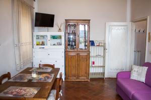 un soggiorno con tavolo e divano viola di Santa Croce Charme Apartment ad Arezzo