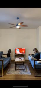 a woman sitting on a couch in a living room at Sava apartment in Novi Sad